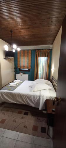 ネオコリにあるKynthia Guesthouseの木製の天井のベッドルーム1室(大型ベッド1台付)
