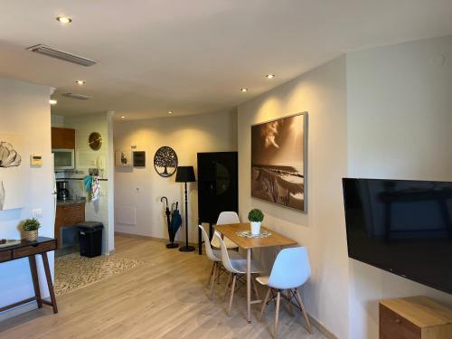 a living room with a table and chairs and a television at La Laguna Luxe Apartment in La Laguna