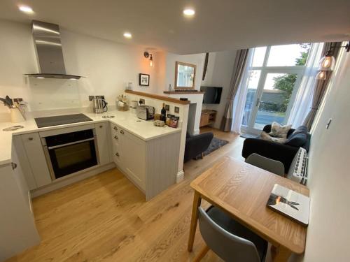 a kitchen and living room with a table and a dining room at Brigstone Stable - charming peaceful cottage in Lothersdale
