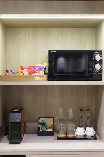 a microwave sitting on top of a shelf at Fifth Pattaya Jomtien By Shiwalai Int in Jomtien Beach
