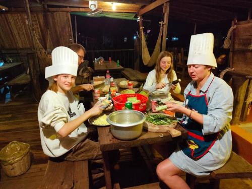 a group of people in chefs hats preparing food at a table at ST 63 Home Stay & Tour Kampong Khleang in Kâmpóng Khleăng