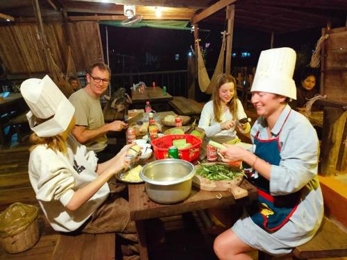 a group of people wearing chefs hats sitting around a table at ST 63 Home Stay & Tour Kampong Khleang in Kâmpóng Khleăng