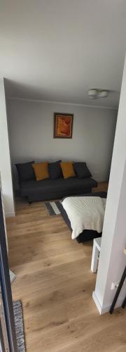 a couch in a room with a wooden floor at Seaside_albatross in Ķesterciems