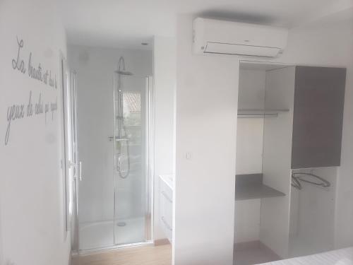 Biała łazienka z prysznicem i szklanymi drzwiami w obiekcie Six-fours les plages w mieście Six-Fours-les-Plages