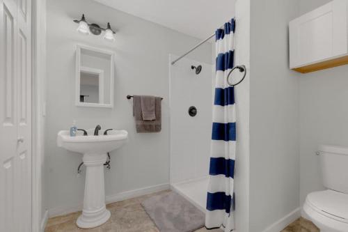 a white bathroom with a sink and a toilet at Near Bishop Arts District Spacious 3 Bedroom Home! in Dallas
