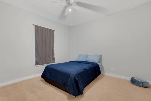 a bedroom with a blue bed in a white room at Near Bishop Arts District Spacious 3 Bedroom Home! in Dallas
