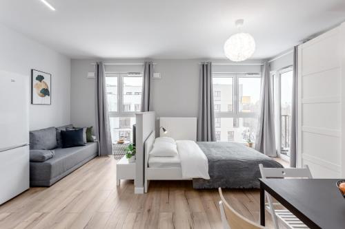 a white bedroom with a bed and a couch at Warsaw City North in Warsaw