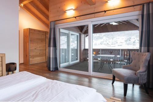 a bedroom with a bed and a balcony with a table at Apartment Renata in Grindelwald