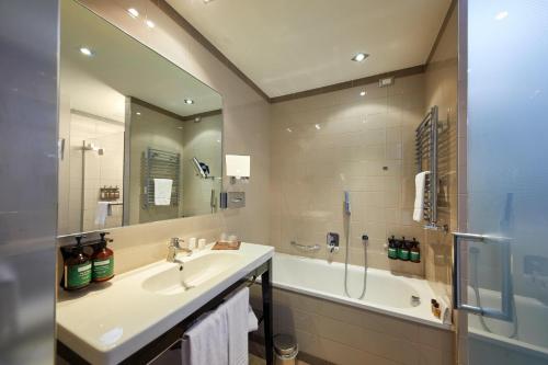 a bathroom with a sink and a shower and a tub at Crowne Plaza Verona Fiera by IHG in Verona