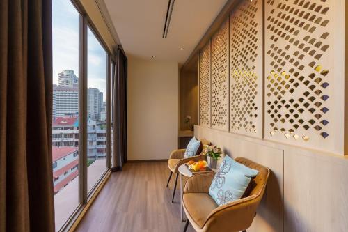 a room with two chairs and a table and a window at Fifth Pattaya Jomtien By Shiwalai Int in Jomtien Beach