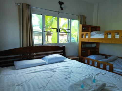 a bedroom with two bunk beds and a window at Open Kitchen in Chiang Rai