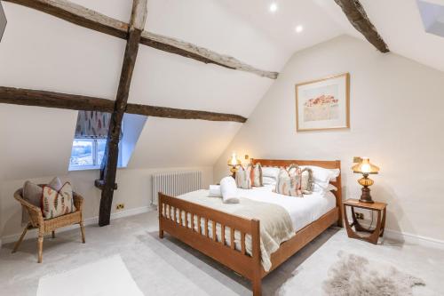 a bedroom with a bed and a chair at Bankside Cottage in Blockley