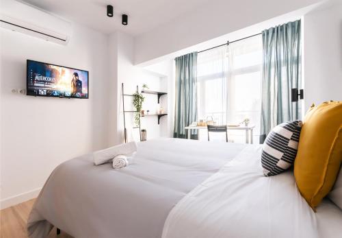 a white bedroom with a large white bed and a window at Nordik Rooms Urban - Centro "Helsinki" in Málaga