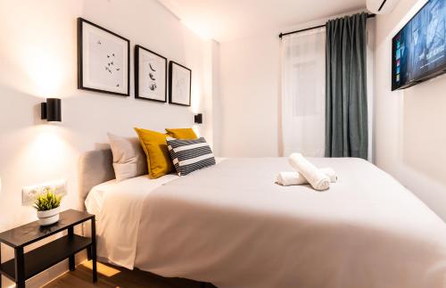 - une chambre avec un grand lit blanc et une fenêtre dans l'établissement Nordik Rooms Urban - Centro "Helsinki", à Malaga