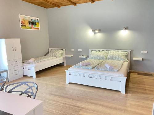 PačirにあるJulia Apartmanのベッドルーム1室(ベッド2台、テーブル、椅子付)