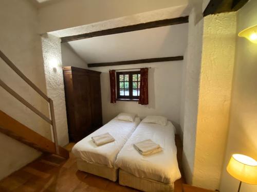 a bedroom with a bed with two towels on it at Cosy former bakery house with communal swimming pool in Prayssac