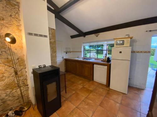 a kitchen with a white refrigerator and a stove at Cosy former bakery house with communal swimming pool in Prayssac