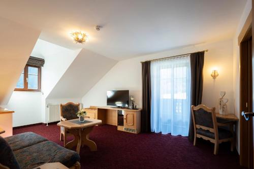 a living room with a couch and a table and a television at DAS Hintersee in Hintersee