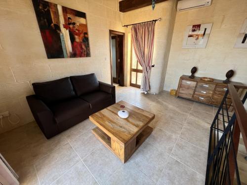 a living room with a couch and a coffee table at T'Anna Farmhouse in Nadur