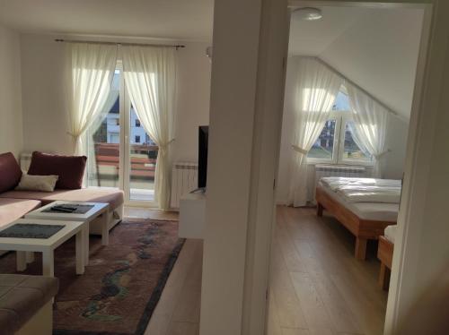 a living room with a couch and a bed at Apartman MiMa in Pale