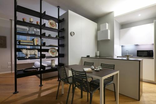 uma cozinha e sala de jantar com mesa e cadeiras em Contempora Apartments - Visconti di Modrone em Milão