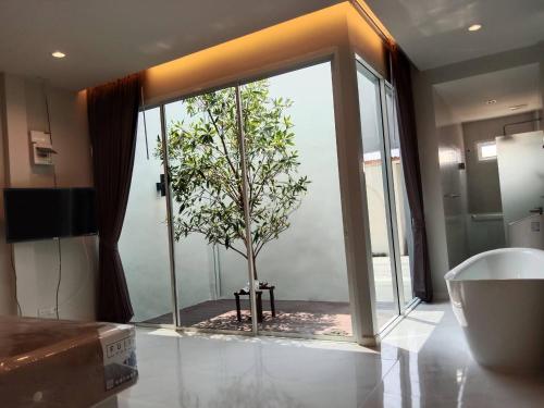 a bathroom with a tree outside of a window at PVILLA in Ban Phraek Sa