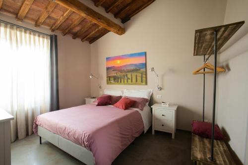 um quarto com uma cama e um quadro na parede em La finestra sulla Torre em Siena