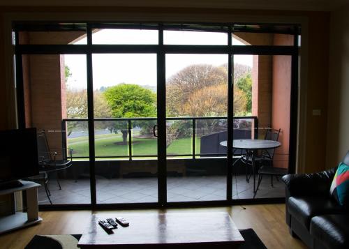a living room with a large glass door leading to a patio at merseybank apartments in Devonport