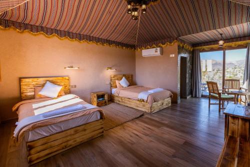 een slaapkamer met 2 bedden en een tafel en stoelen bij Jebel Shams Resort منتجع جبل شمس in Dār Sawdāʼ
