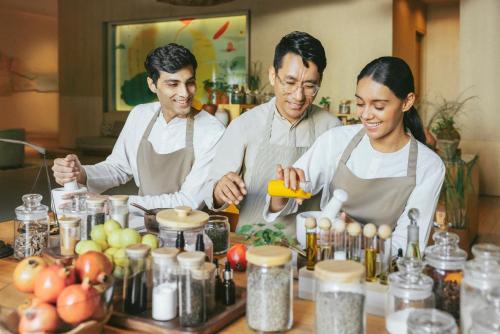 a group of three people standing in a kitchen preparing food at Six Senses Vana - A Wellness Retreat in Dehradun
