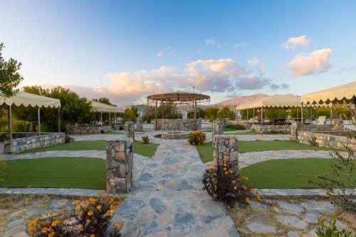 a view of a garden with umbrellas and grass at Jebel Shams Resort منتجع جبل شمس in Dār Sawdāʼ