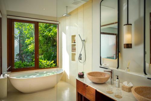 a bathroom with a tub and a sink and a window at WAKA VILLA Private Pool Resort & Spa - Adults Only in Siem Reap