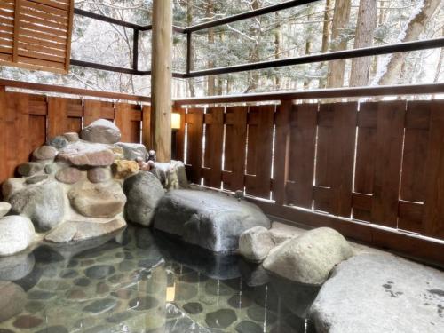 a rock garden with rocks in the middle of a room at 一棟貸切 森のお風呂とアウトドアサウナ 日光雪月花 in Nikko
