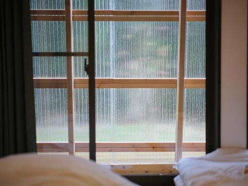 a bedroom with a window covered in rain at WAY SHIRAKAWAGO - Free Parking and Newly Opened 2022 WAY SHIRAKAWAGO in Shirakawa