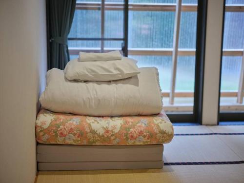 a stack of pillows sitting on a couch in front of a window at WAY SHIRAKAWAGO - Free Parking and Newly Opened 2022 WAY SHIRAKAWAGO in Shirakawa