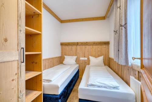 two beds in a room with wooden shelves at Appartement Hofmann in Königsleiten
