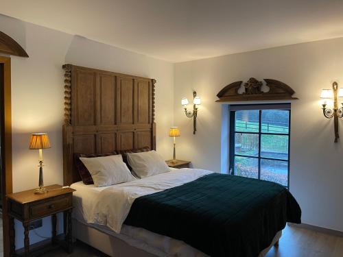 a bedroom with a large bed and a window at Les Confidences de Messire Sanglier, stylished guest houses in Beauraing