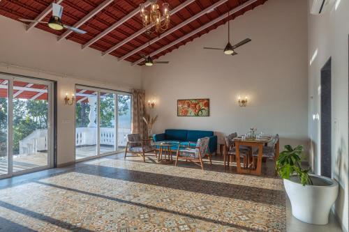 a living room with a couch and a table at SaffronStays Mariposa by the River Sol, Karjat in Karjat