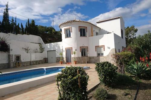 uma casa branca com uma piscina em frente em Countryside private apartment with pool & sea view em Torrox