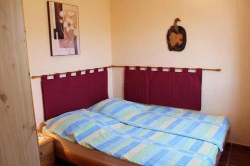 um quarto com uma cama com um edredão vermelho e azul em Countryside private apartment with pool & sea view em Torrox