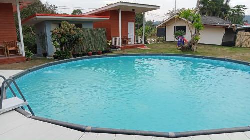 uma grande piscina azul em frente a uma casa em Paa & Michaels Resort 