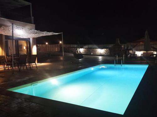 una piscina iluminada por la noche en VILLA NDJ RELAX, en Tsoukaladhes