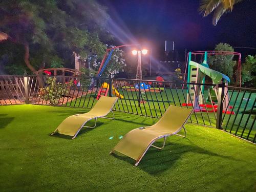 dos sillas sentadas en un patio de juegos por la noche en Finca Villa Rey, en Ardales