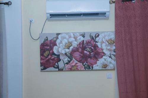a picture of flowers hanging on a wall at Résidence Fé in Douala