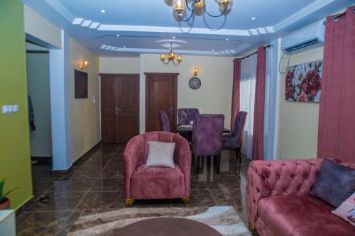 uma sala de estar com um sofá, uma mesa e cadeiras em Résidence Fé em Douala