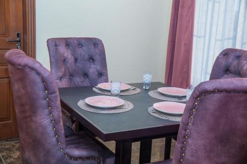 a dining room table with plates and glasses on it at Résidence Fé in Douala