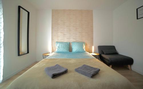 um quarto com uma cama com duas toalhas em B&B Chambre Privative Chez L'habitant Sur La Route Des Vins Parking Box vélo em Issenheim