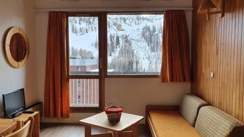 un salon avec un canapé et une grande fenêtre dans l'établissement Front de neige Panoramique, à Isola 2000