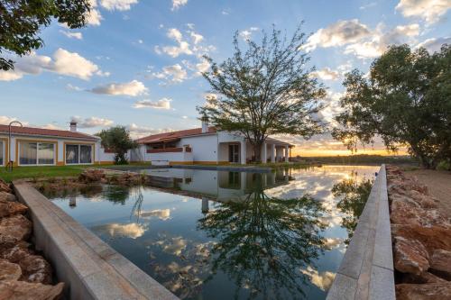 a pool of water in front of a house at Quinta Marugo Retreats in Serpa