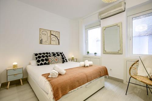 a white bedroom with a bed and two windows at Apartamento Plaza España, Madrid in Madrid